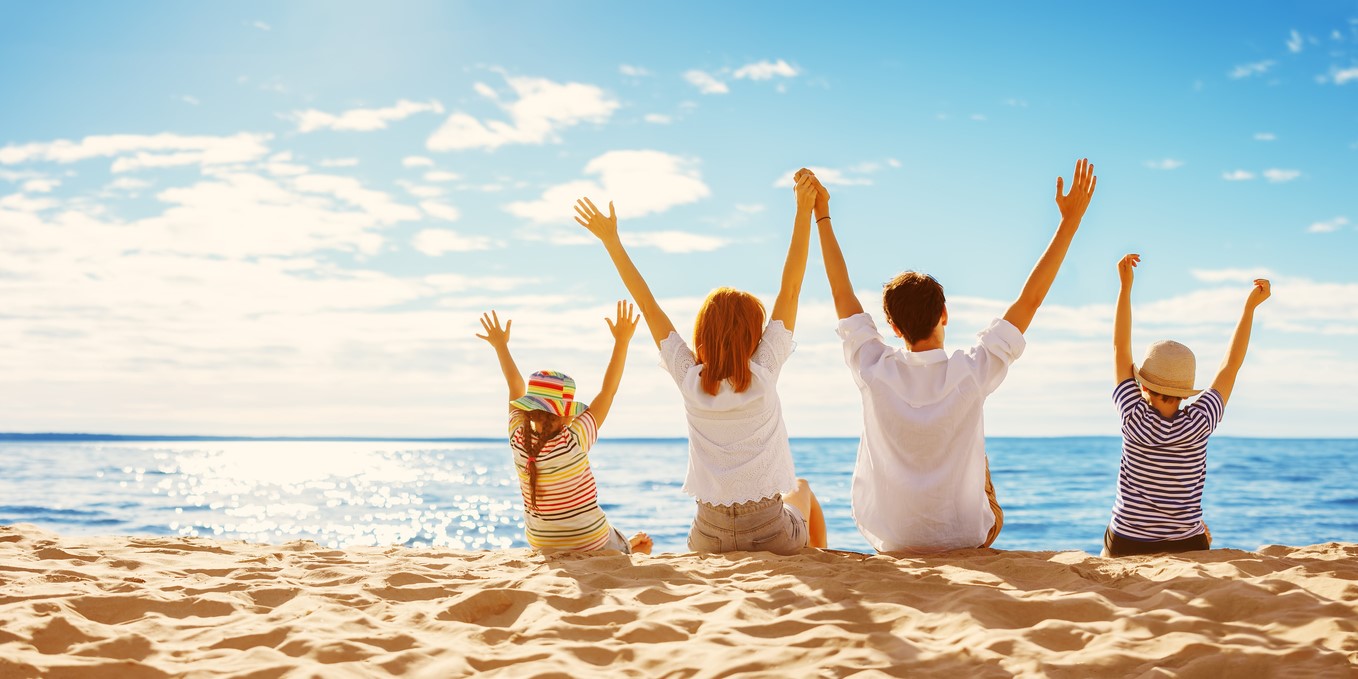 Familienurlaub am Strand, familie mit Kindern mit händen in der luft, Sonnenhüte